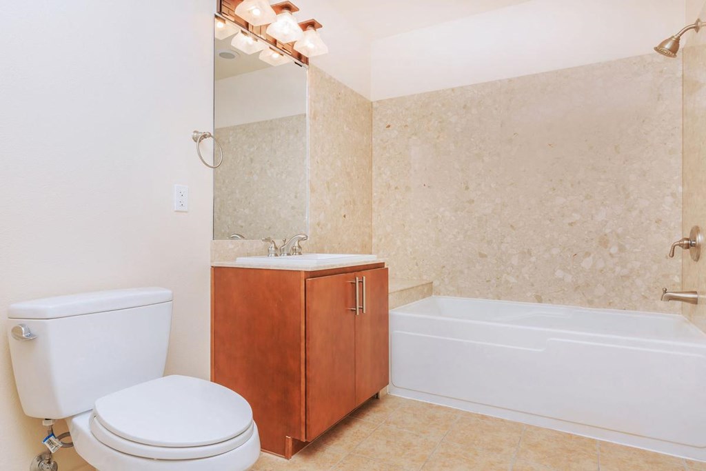 a bathroom with a toilet and a tub and a sink