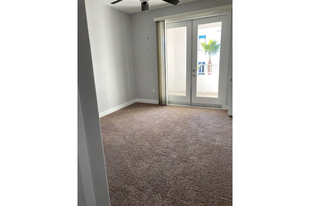 an empty living room with a door to a patio