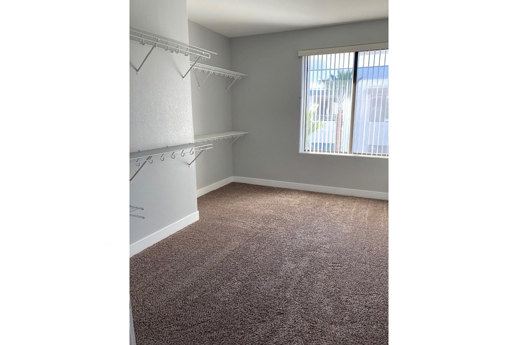 an empty room with a closet and a window