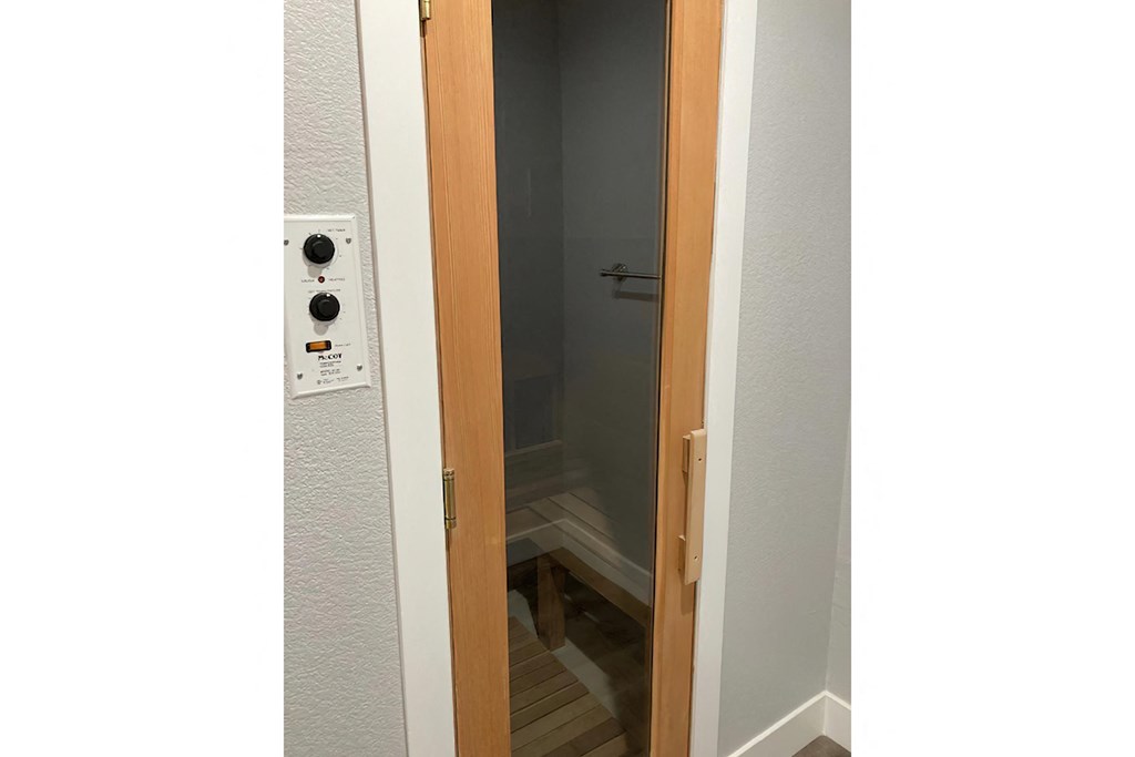 the door is open to a small bathroom with a shower