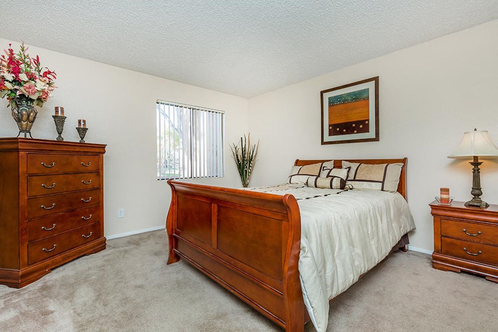 a bedroom with a bed and two dressers