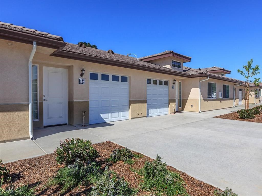 a house with two garage doors and a cement driveway