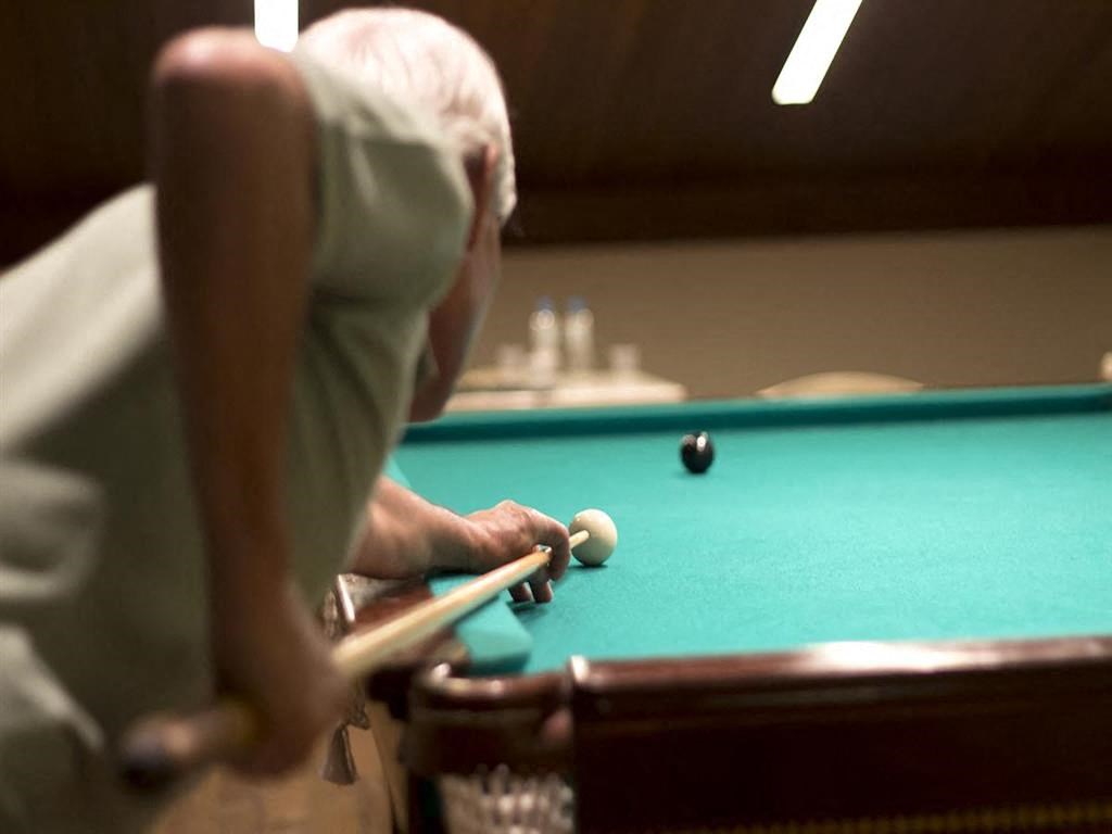 an older man playing a game of pool