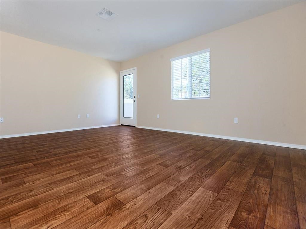 a living room with a hard wood floor and a window
