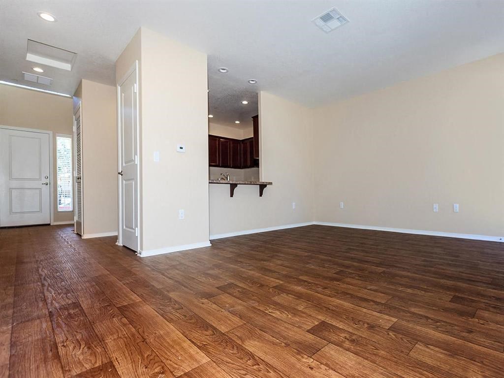 an empty living room with a hard wood floor