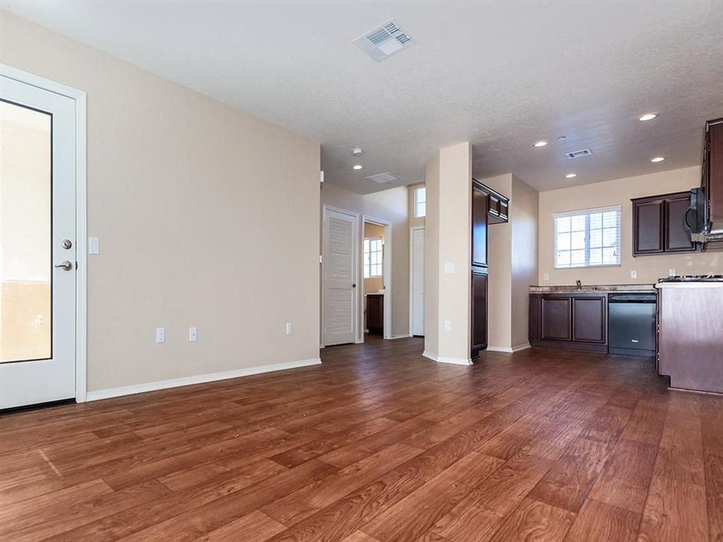 an empty kitchen and living room with wood floors