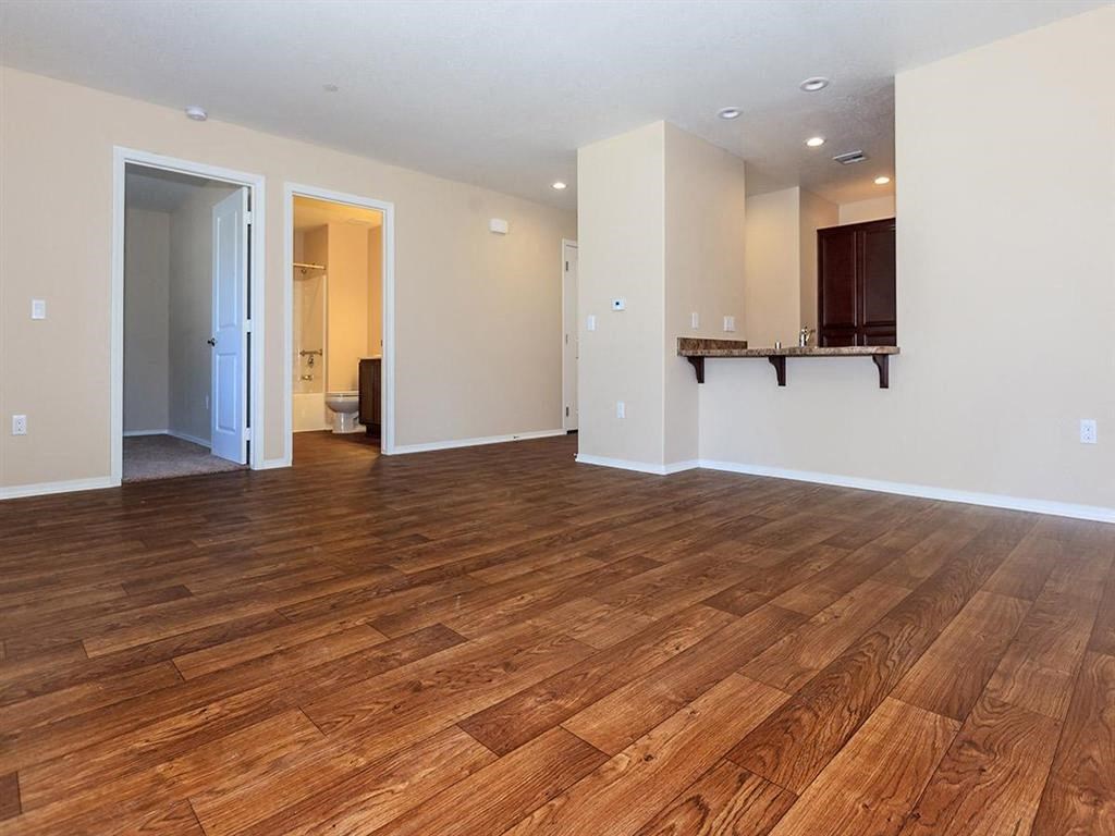 an empty living room with a wood floor