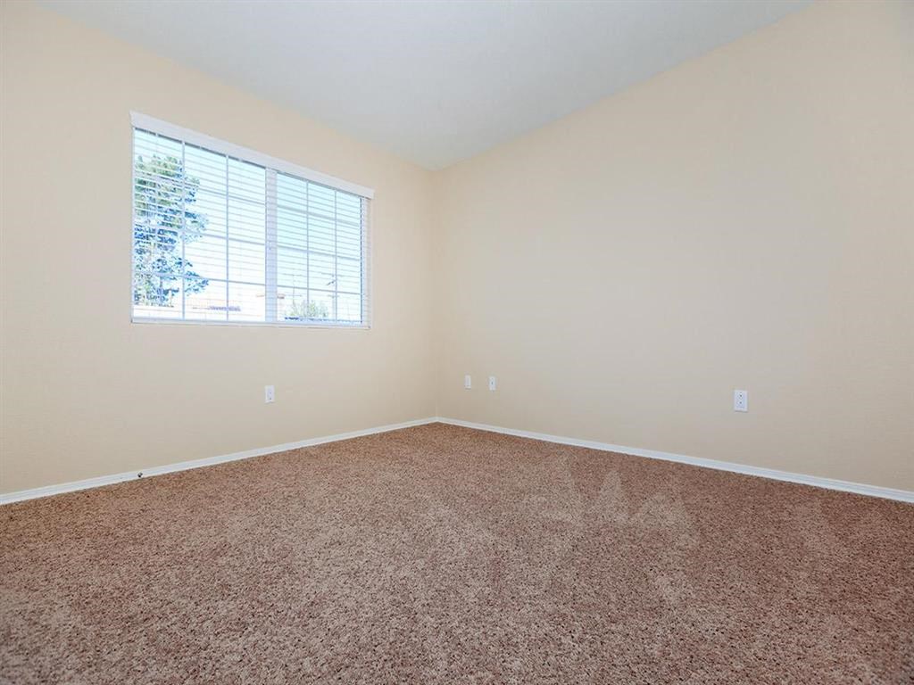 an empty room with carpet and a window