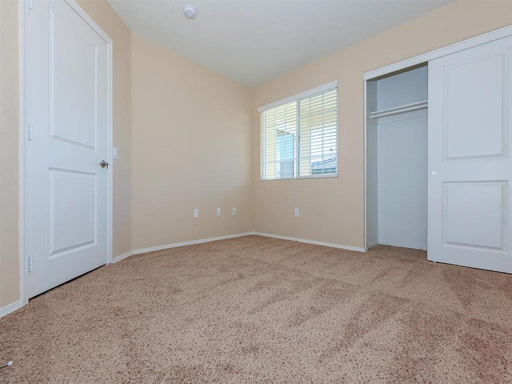 an empty living room with a door to a closet
