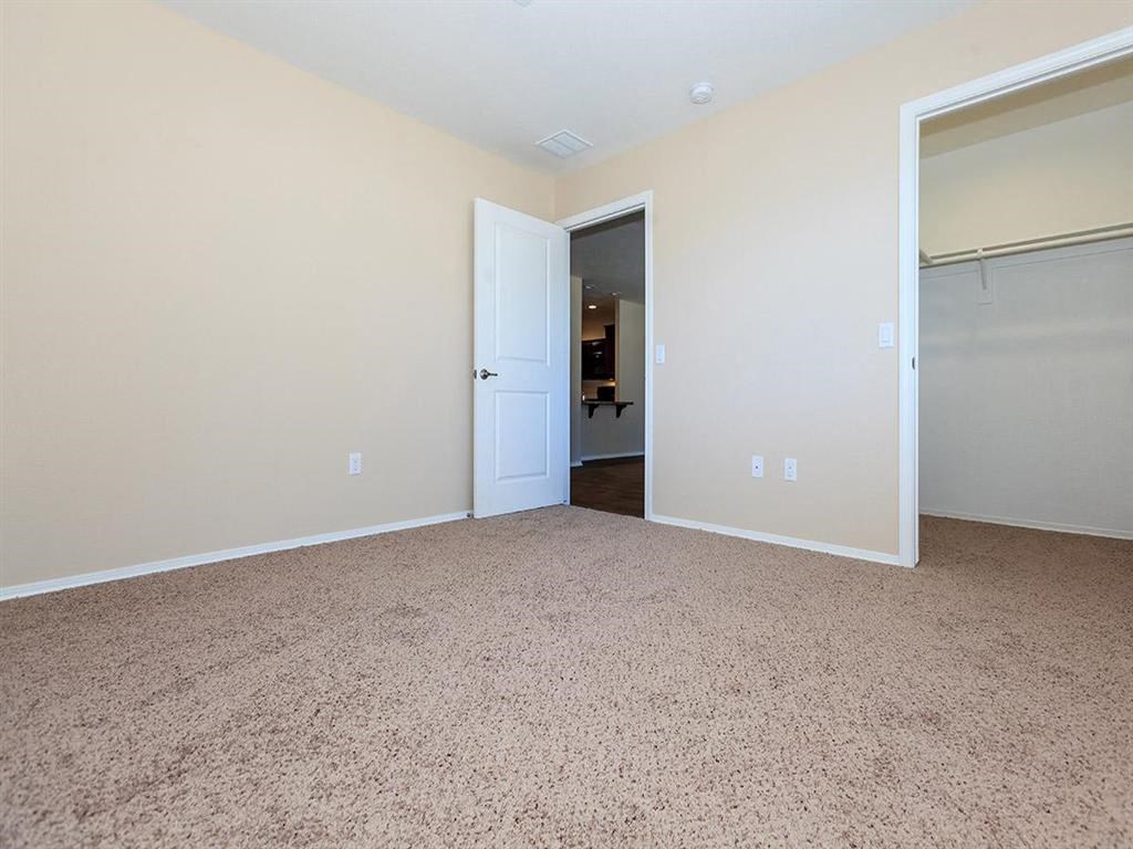 an empty living room with a door to a closet