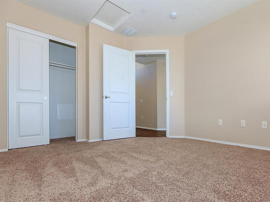 an empty room with two doors and a carpeted floor