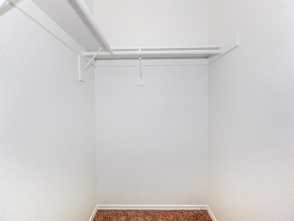 an empty room with white walls and a red rug