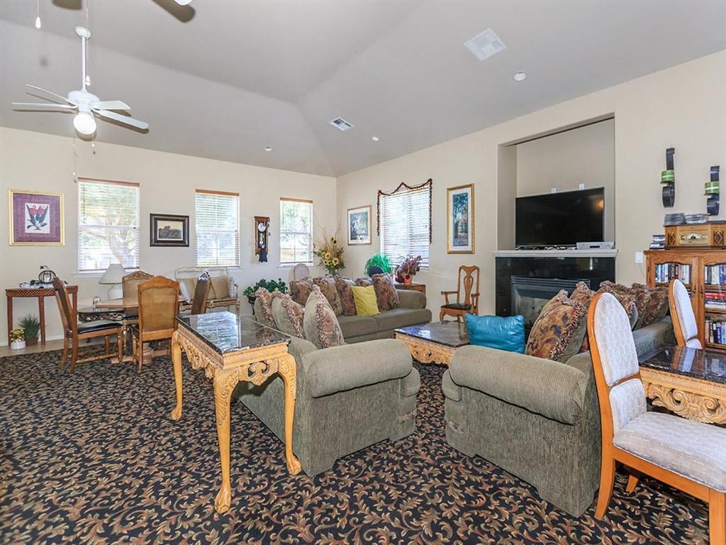 a living room with couches and chairs and a television