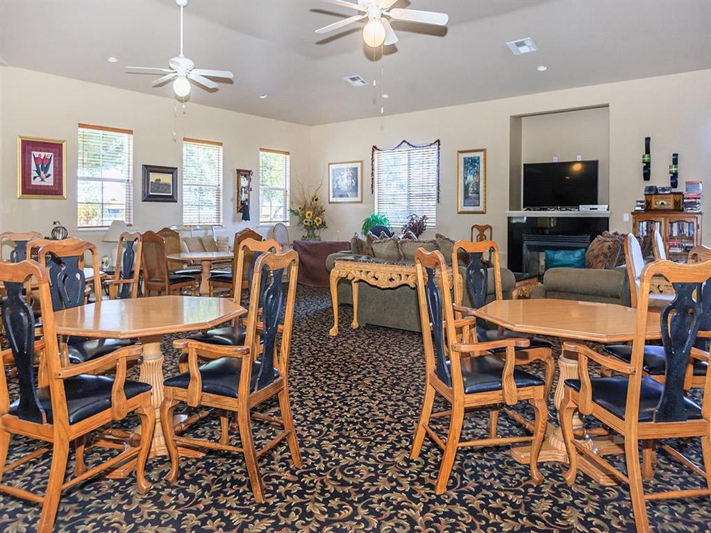 a living room with wooden tables and chairs and a television