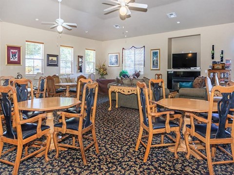 a living room with wooden tables and chairs and a television