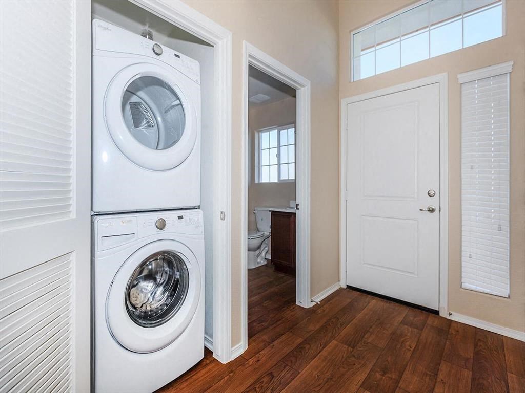 a white washer and dryer in a room with a door to a bathroom