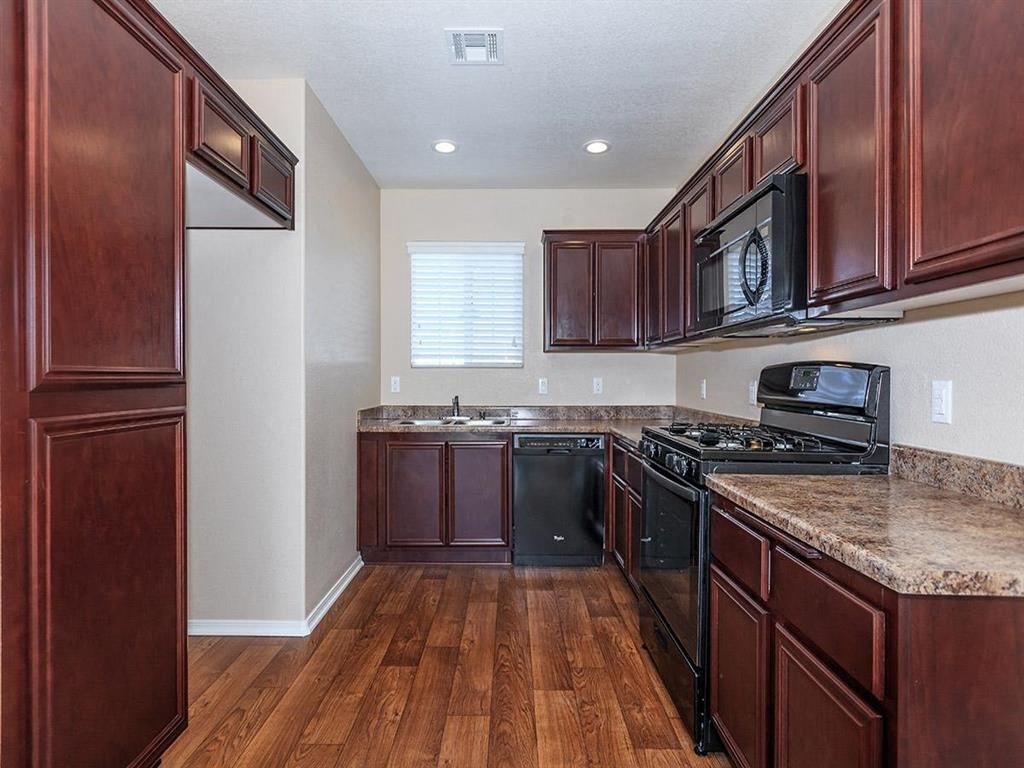 a kitchen with wooden cabinets and black appliances
