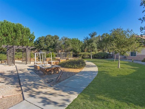 a walkway through a park with a playground and trees