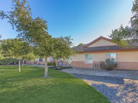 the front of a house with a yard and trees