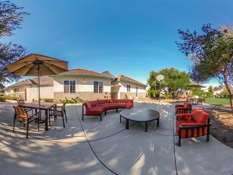 a patio with chairs tables and umbrellas