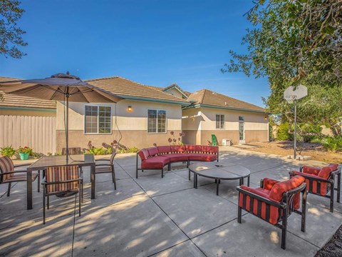 a patio with tables and chairs and a basketball hoop
