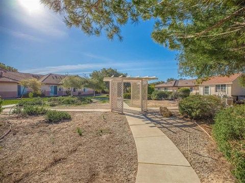 a walkway with a fence and houses in the background