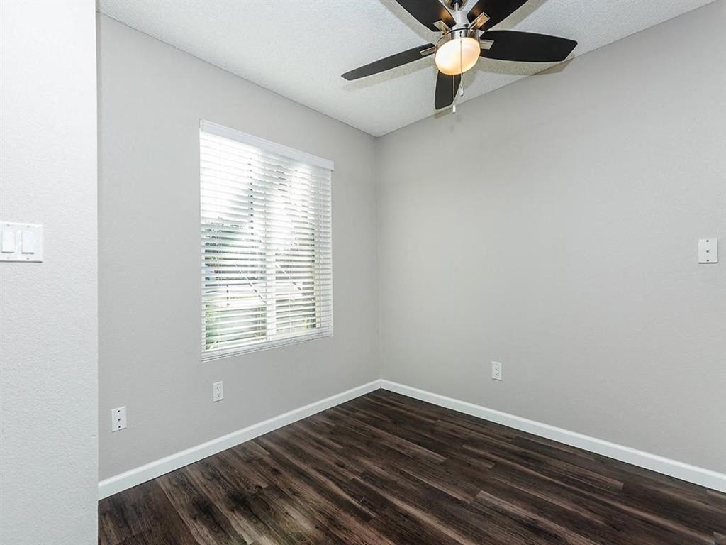 an empty room with a ceiling fan and a window