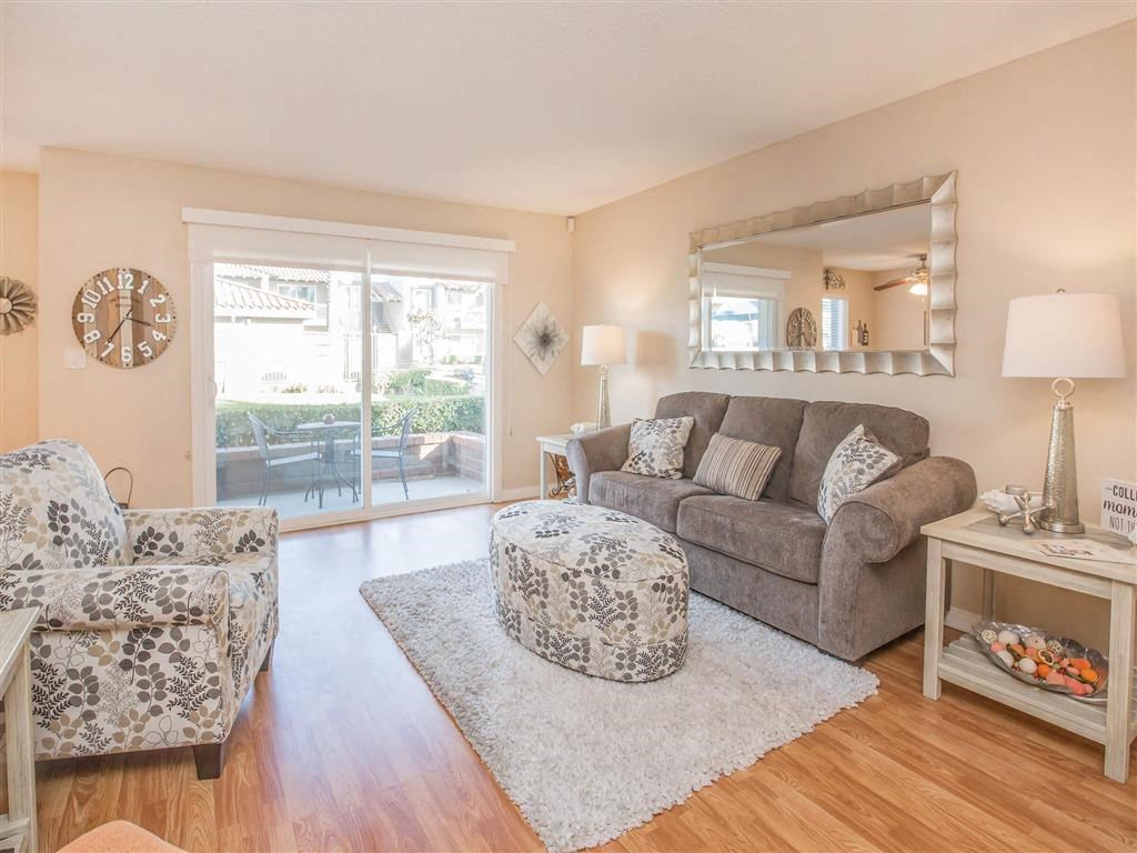 a living room with a couch and a chair and a mirror