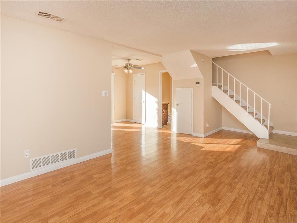 an empty living room with a hard wood floor and a staircase