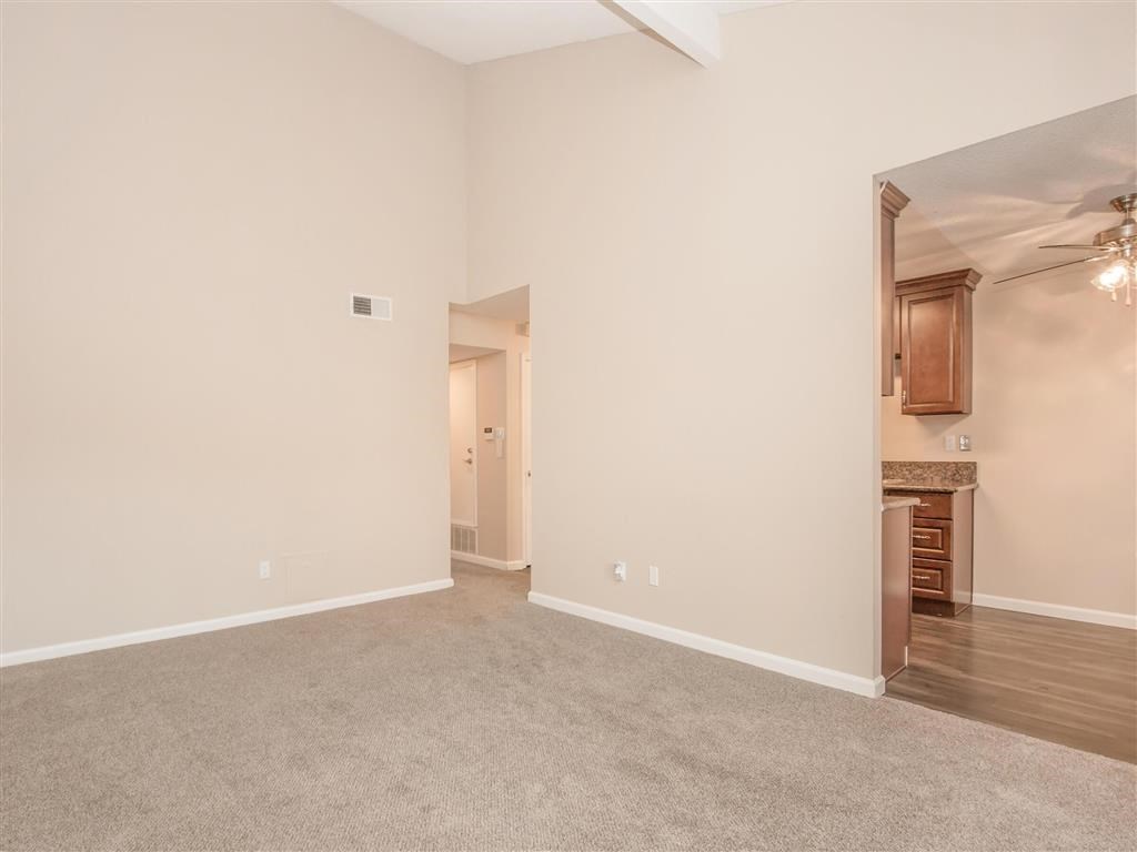 the living room and dining room of an empty home with white walls