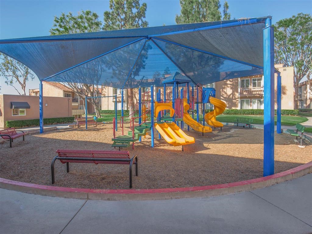 a playground with slides and a bench in a park