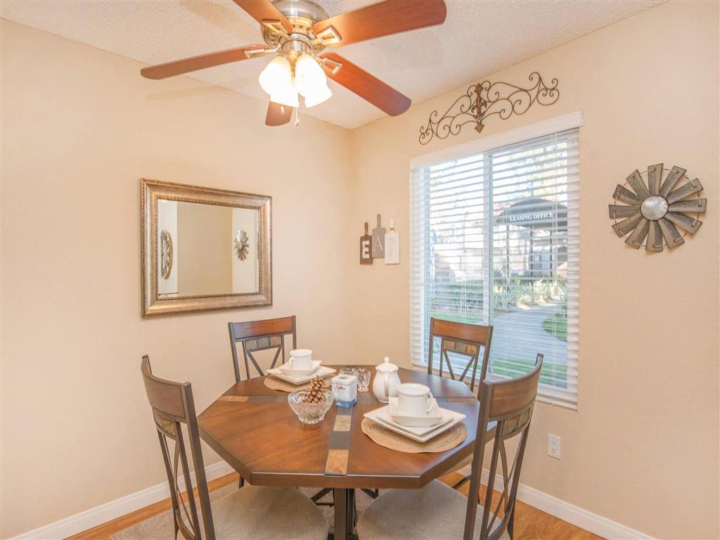 a dining room with a table and chairs and a ceiling fan