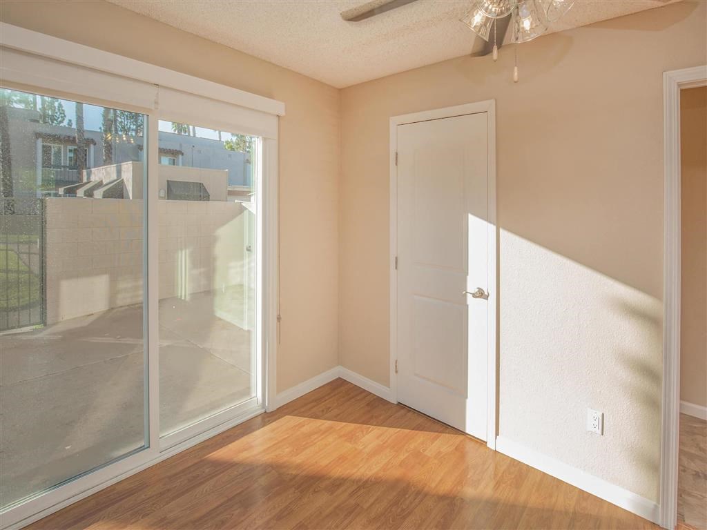 an empty living room with a door to a balcony