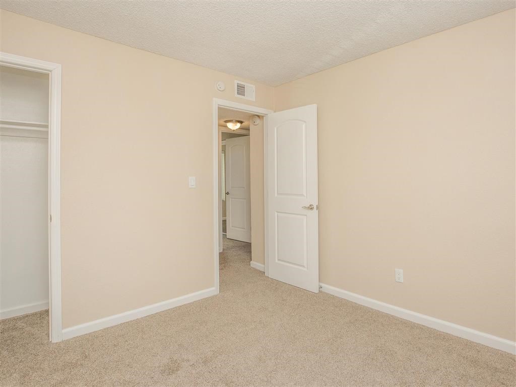 a bedroom with an open door and a hallway to a closet