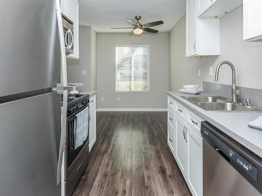 a kitchen with stainless steel appliances and a ceiling fan