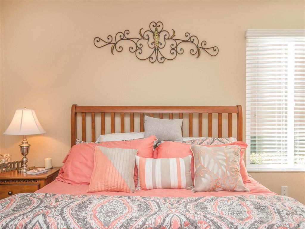 a bedroom with a bed with pillows and a wall art above it