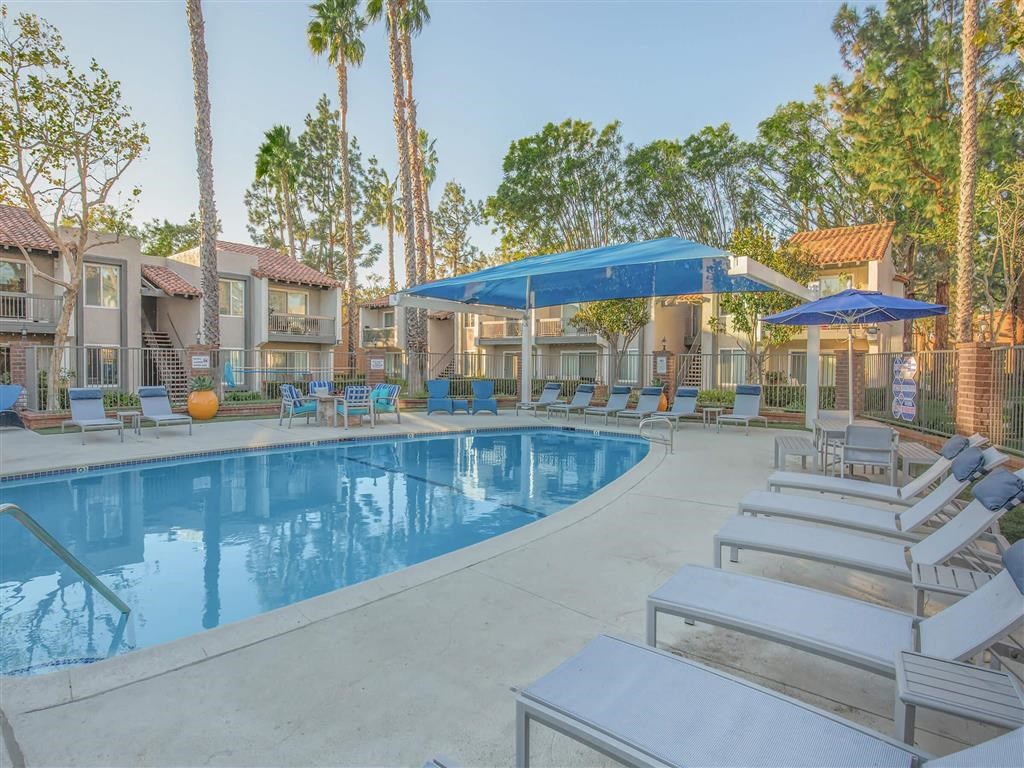 a swimming pool with lounge chairs and umbrellas at the resort
