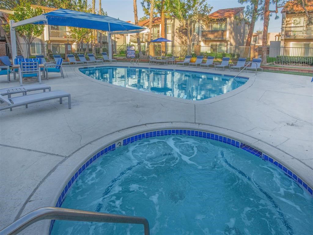 a large pool with chairs and umbrellas in a resort style pool