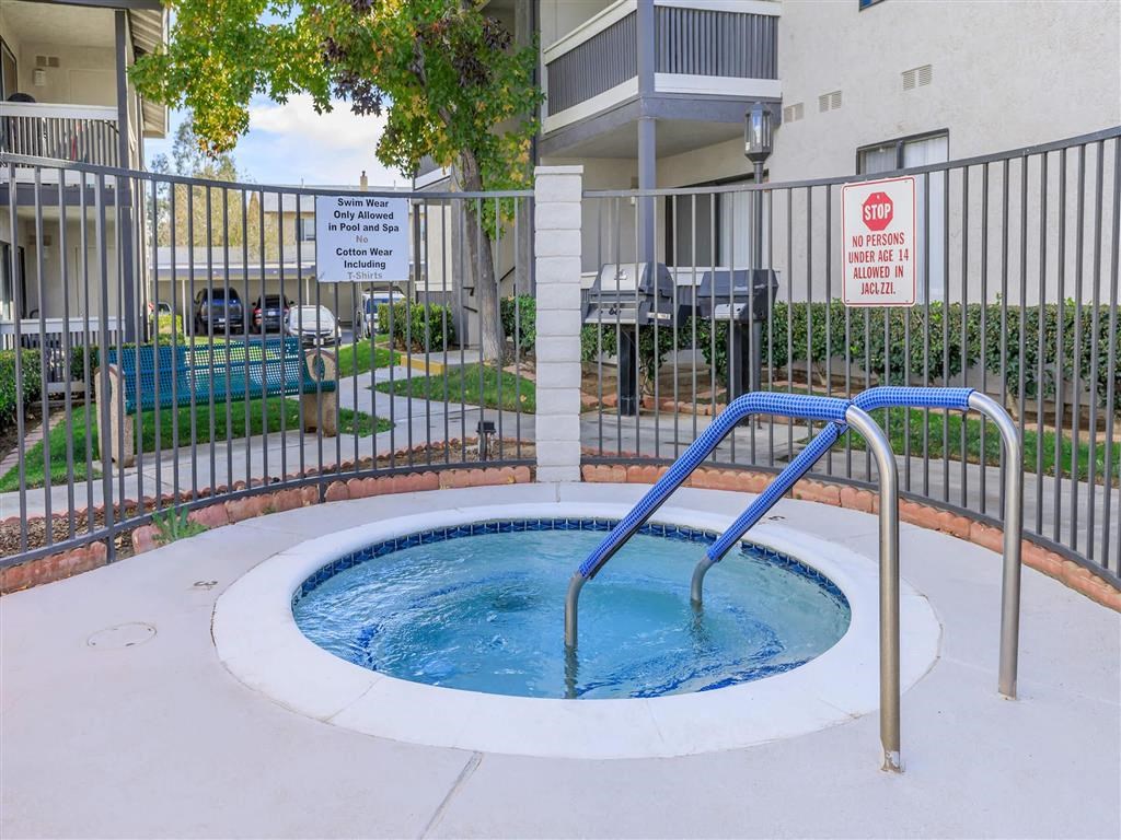 a jacuzzi in a pool in front of an apartment building