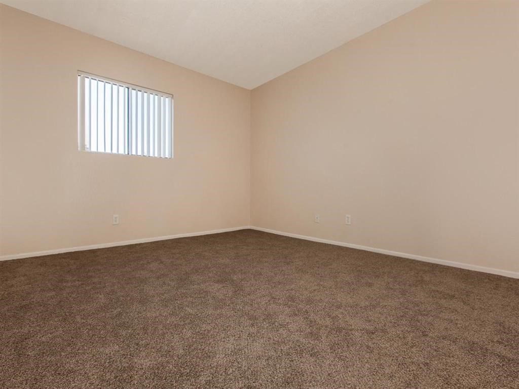 an empty living room with carpet and a window