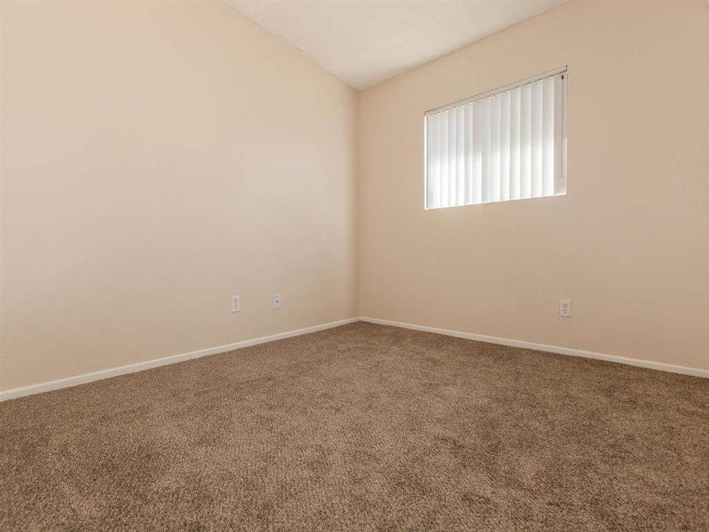 an empty room with carpet and a window