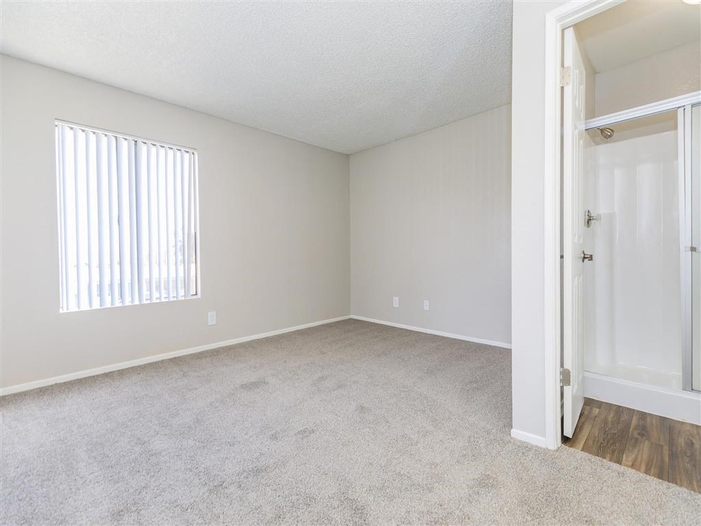 an empty bedroom with a door to a closet