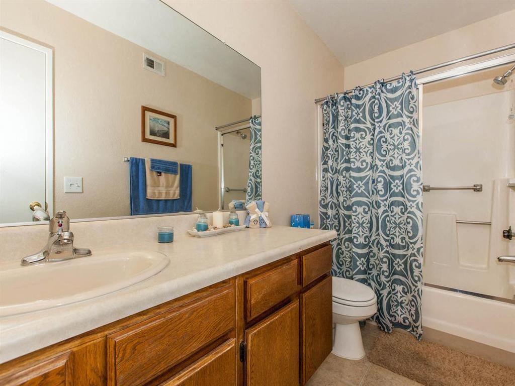 a bathroom with a large mirror and a sink and a toilet