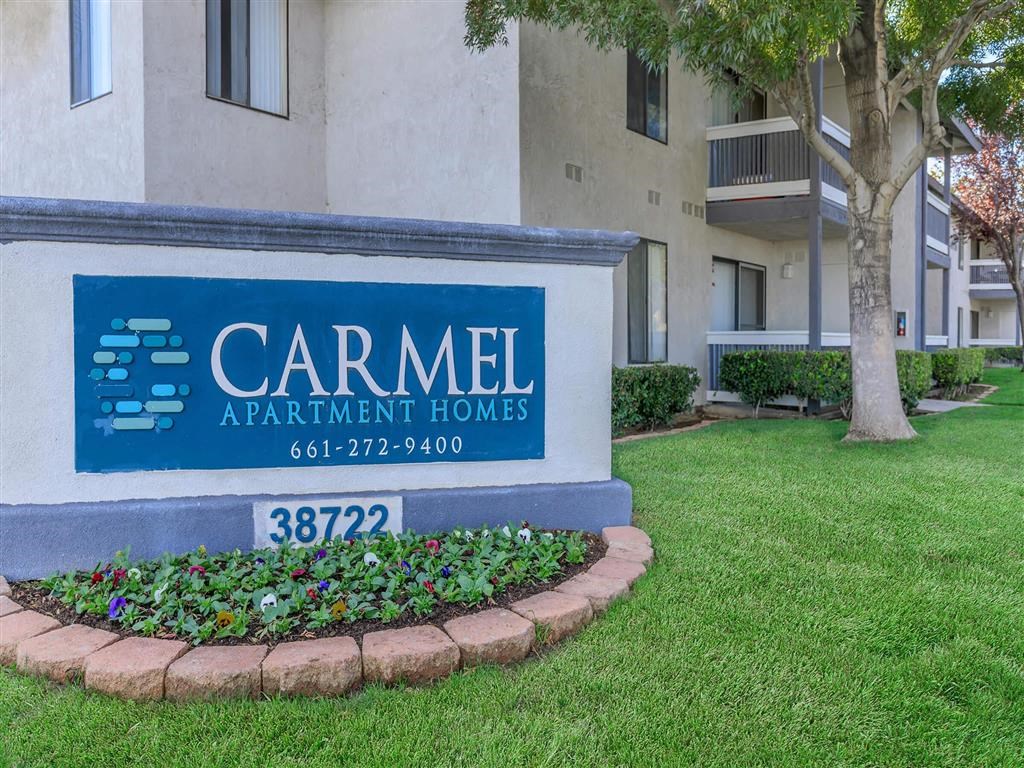 an apartment building with a sign for carmen apartment homes