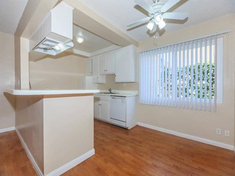 A kitchen with a white dishwasher and a ceiling fan.