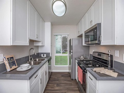 A kitchen with white cabinets and a black stove top oven.