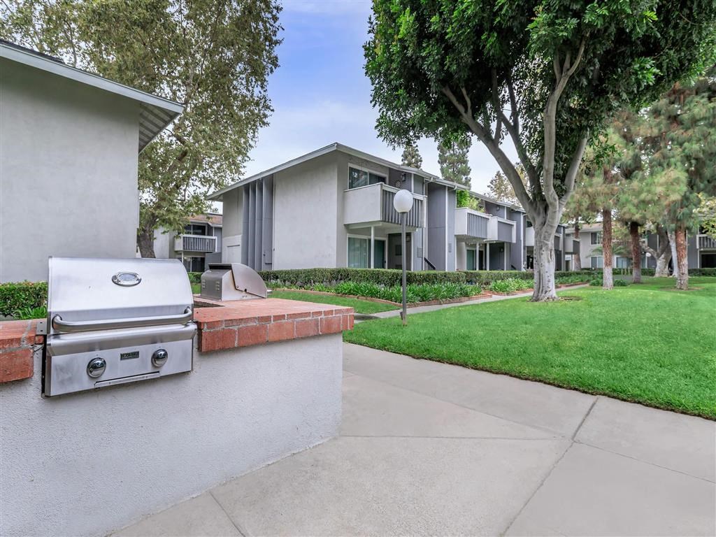 a grill is sitting on a wall in front of a house