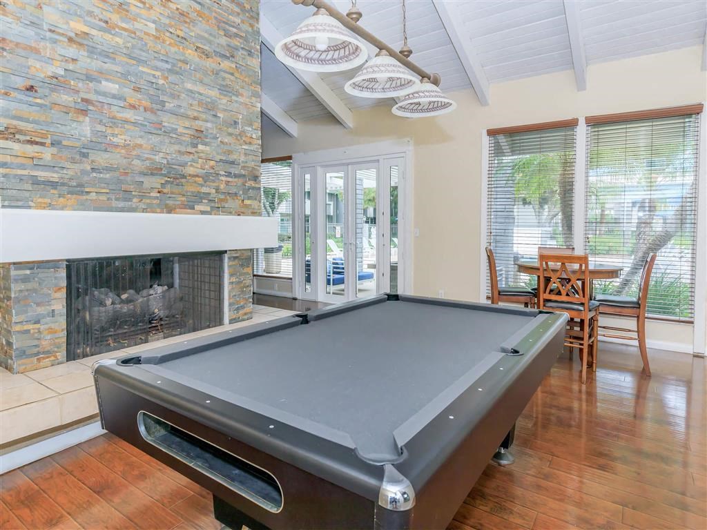 a pool table in a living room with a fireplace
