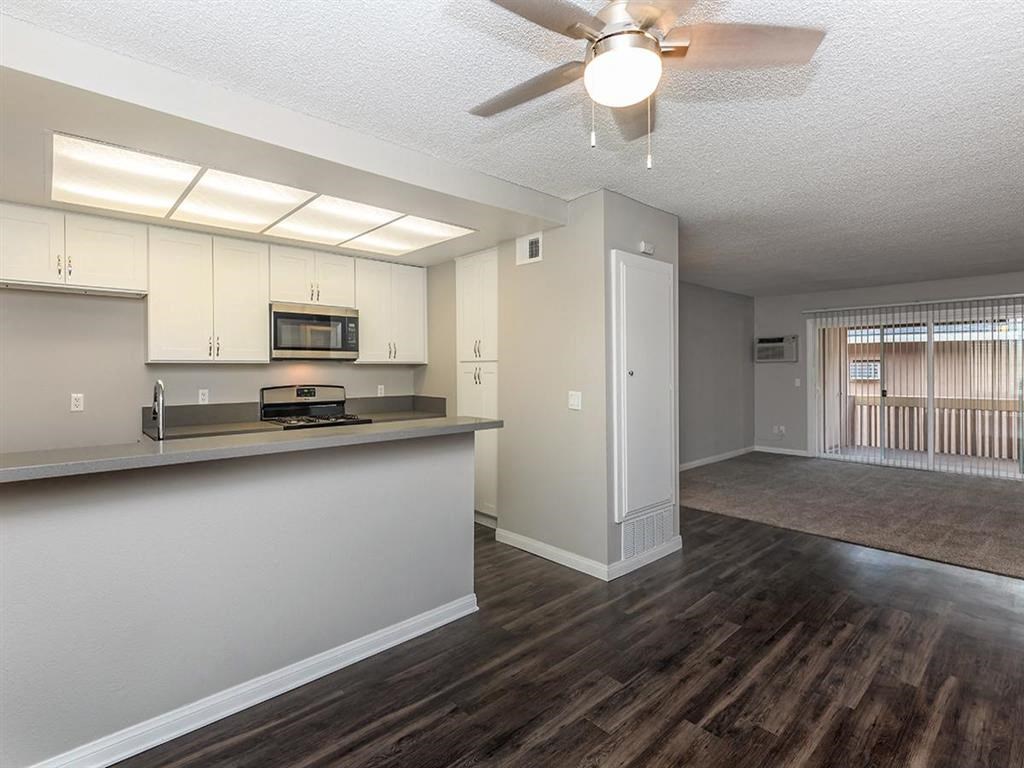 an empty kitchen and living room with a ceiling fan