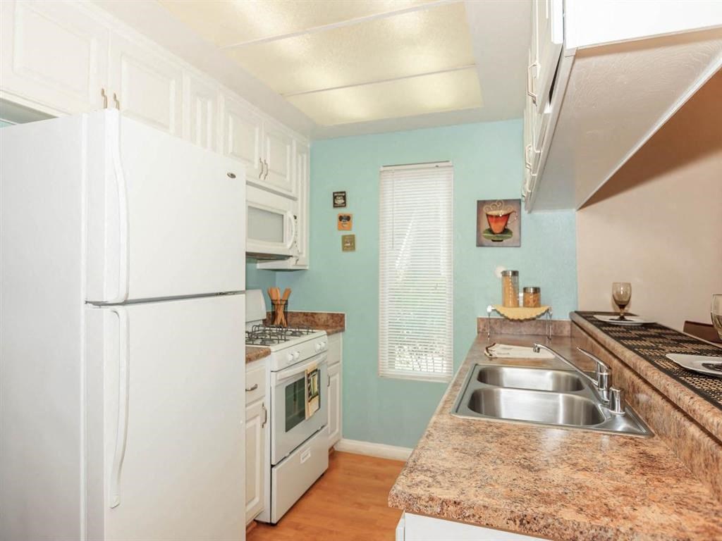 a kitchen with a stove refrigerator and a sink
